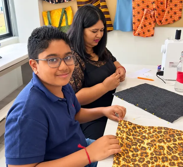 Priya's son at a sewing machine