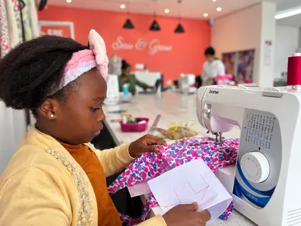 Sew & Grow student &mdash; pattern in one hand, fabric in the other
