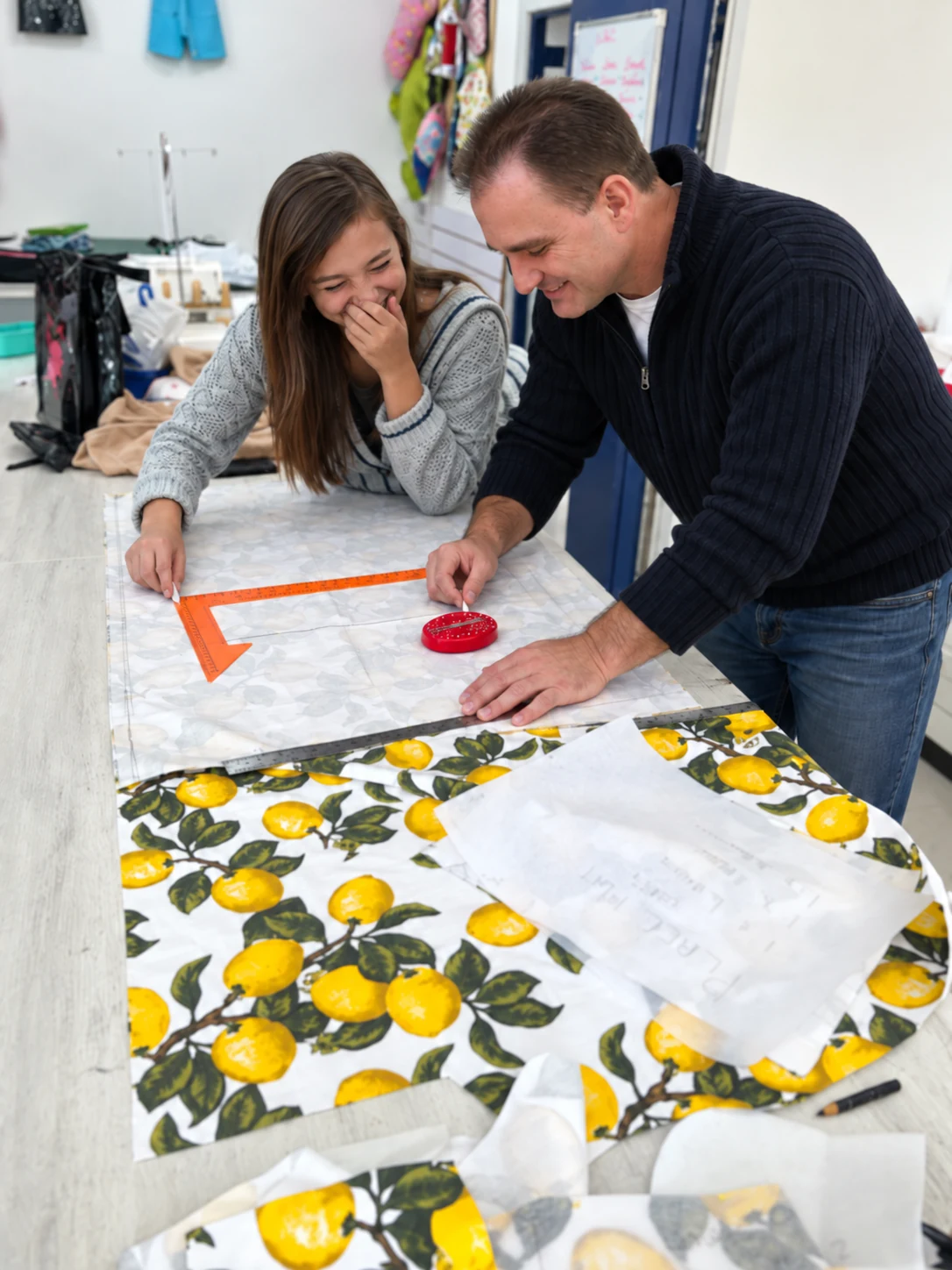 A father and daughter laughing together over a pattern at Sew & Grow