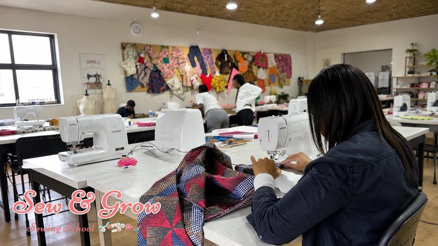 A student sewing colourful patchwork at her machine in class