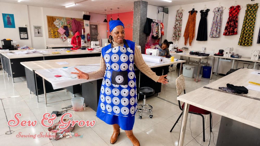 A cheerful student standing in the studio with arms open wide