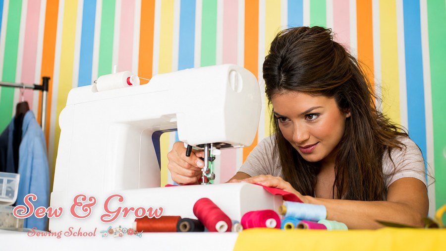 A woman sewing bright fabric at her machine among colourful threads