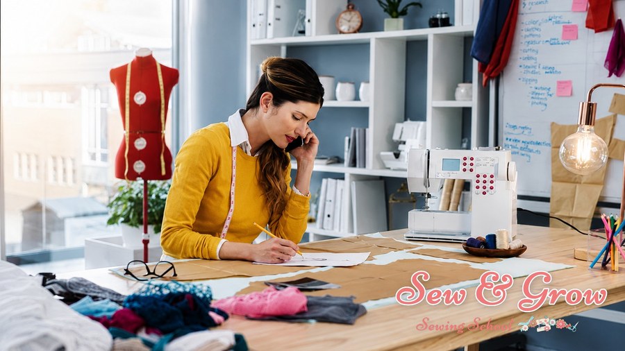 A dressmaker on the phone while sketching a design in her studio