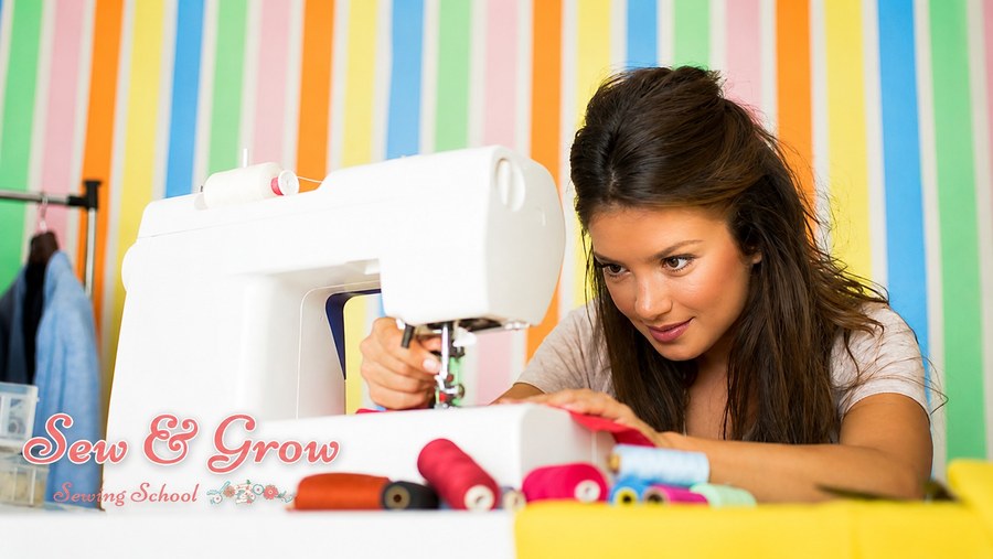 A woman sewing bright fabric at her machine among colourful threads