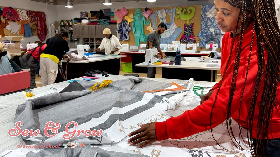 A student laying out striped fabric on the cutting table in class