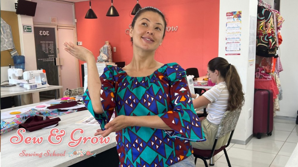 A student showing off a colourful handmade top in the studio
