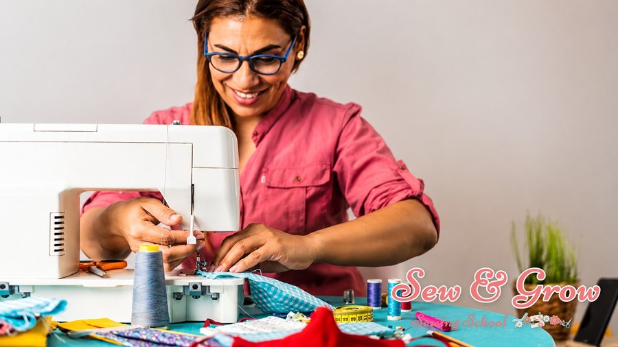 A smiling woman sewing at her machine with colourful threads